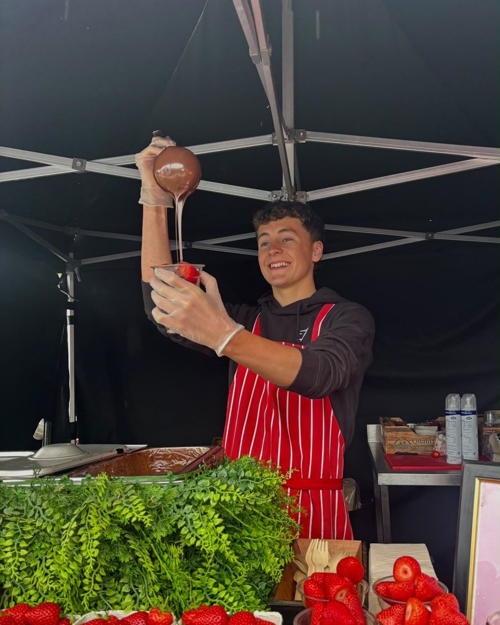 Pouring chocolate over strawberries at the strawberry bar